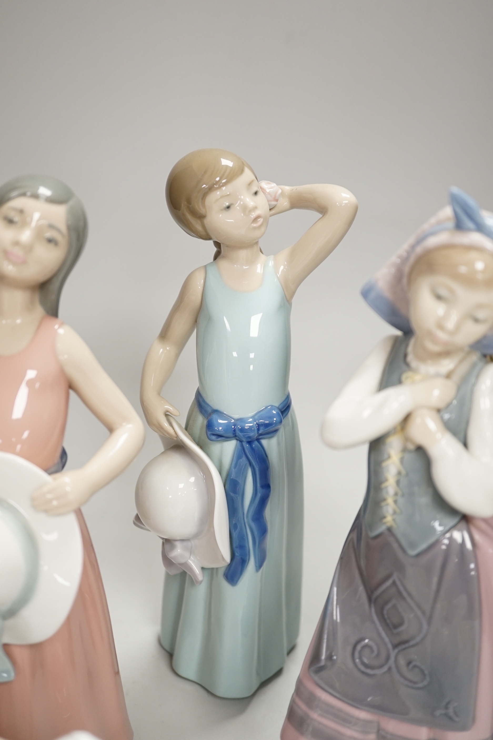 Six Lladro figures of girls, three with hats, one with a Teddy, two peasant girls with flowers and two Nao ducks, the largest 26cm high (8)